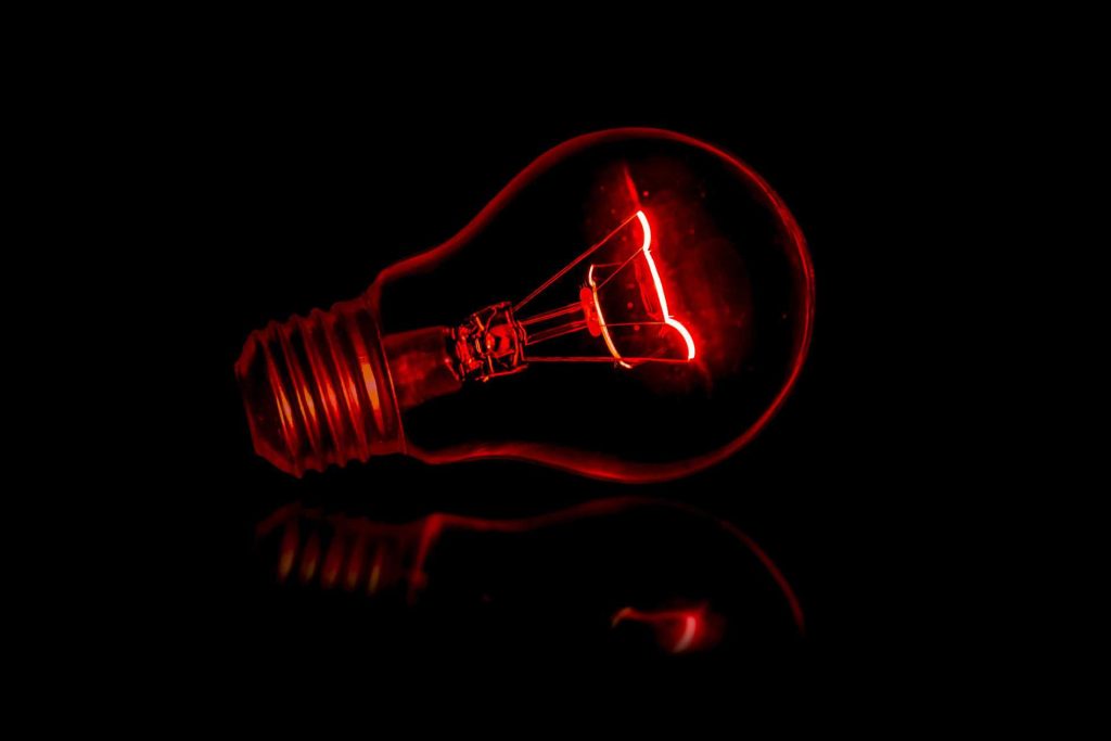 Red lightbulb on dark background